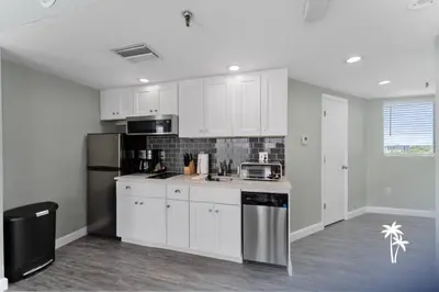 a kitchen with white cabinets and a refrigerator at Lake View Top Floor 2 Bed 2 Bath Condo with Balcony in Orlando