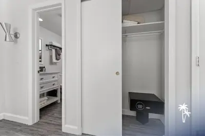 a white bathroom with a closet with a mirror at Lake View Top Floor 2 Bed 2 Bath Condo with Balcony in Orlando