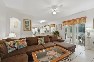 a living room with a brown couch with a table at Near Disney Pool Hot Tub Stunning Water View in Kissimmee