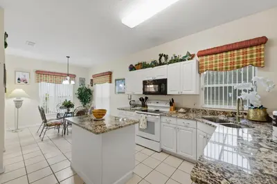 a kitchen with white cabinets and a counter top at Near Disney Pool Hot Tub Stunning Water View in Kissimmee