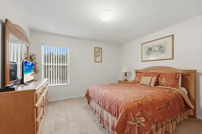 a bedroom with a bed and a flat screen tv at Near Disney Pool Hot Tub Stunning Water View in Kissimmee