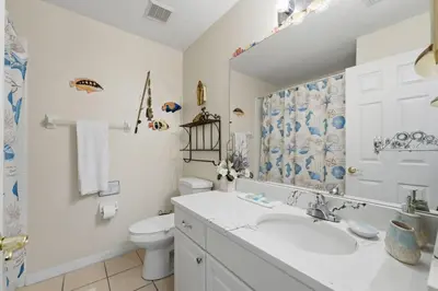 a white bathroom with a sink and a toilet at Near Disney Pool Hot Tub Stunning Water View in Kissimmee