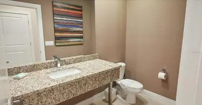 a bathroom with a sink and a toilet at Spacious 4-Suite Villa with Balcony, Magic Village in Orlando