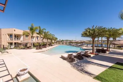a pool at a resort with chairs and palm trees at Spacious 4-Suite Villa with Balcony, Magic Village in Orlando