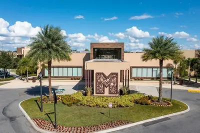 a building with palm trees in front of a street at Spacious 4-Suite Villa with Balcony, Magic Village in Orlando