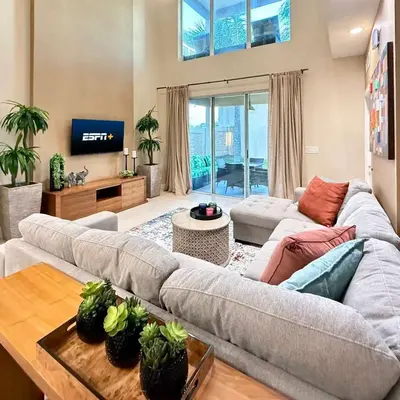 a living room with a couch and a tv at Spacious 4-Suite Villa with Balcony, Magic Village in Orlando