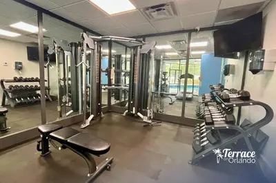 a gym with several tread machines and mirrors at Skyline Studio Condo with Private Terrace and Epic Universe View in Orlando