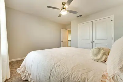 a bedroom with a white bed and a ceiling fan at Pool Access Family Gem with Views in St Cloud! in Saint Cloud