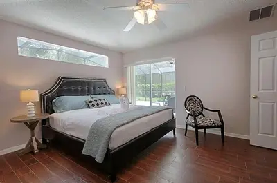 a bedroom with a bed and a ceiling fan at Poolside Vacation Home in Kissimmee Near Disney in Kissimmee