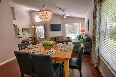 a dining room and living room with a table and chairs at Poolside Vacation Home in Kissimmee Near Disney in Kissimmee
