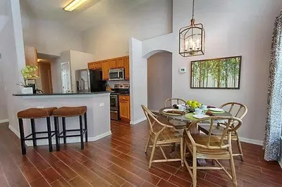 a kitchen and dining room with a table and chairs at Poolside Vacation Home in Kissimmee Near Disney in Kissimmee