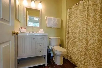 a bathroom with a toilet and a sink and a mirror at Poolside Vacation Home in Kissimmee Near Disney in Kissimmee
