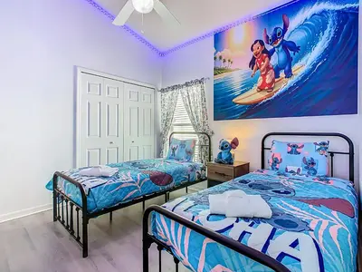 a bedroom with two beds and a painting of a surfer at Themed 4BR villa w spa & pool-Close To Disney in Orlando
