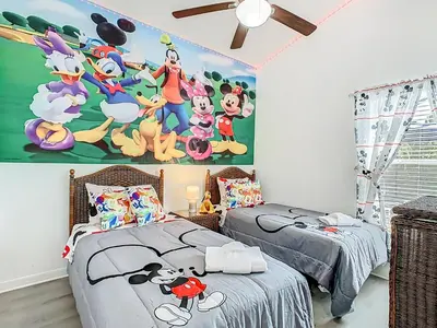 a bedroom with two beds and a painting of mickey mouse at Themed 4BR villa w spa & pool-Close To Disney in Orlando