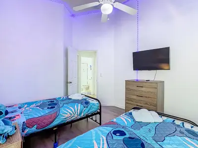 a bedroom with two beds and a flat screen tv at Themed 4BR villa w spa & pool-Close To Disney in Orlando