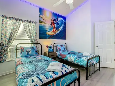 a bedroom with two beds and a painting on the wall at Themed 4BR villa w spa & pool-Close To Disney in Orlando