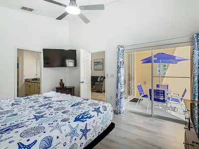 a bedroom with a bed and a balcony with an umbrella at Themed 4BR villa w spa & pool-Close To Disney in Orlando