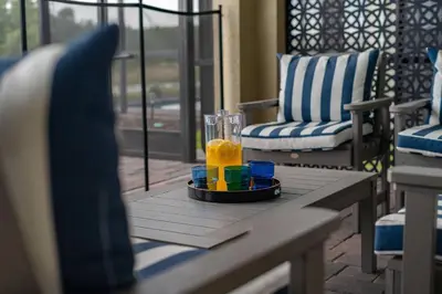 a glass of orange juice on a table on a porch at NEW 9Bdrm S. Facing Pool on Preserve near Dis/Univ in Kissimmee