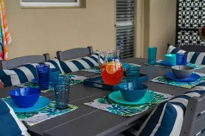 a table with bowls and a pitcher of orange juice at NEW 9Bdrm S. Facing Pool on Preserve near Dis/Univ in Kissimmee