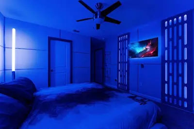 a blue bedroom with a bed and a ceiling fan at NEW 9Bdrm S. Facing Pool on Preserve near Dis/Univ in Kissimmee