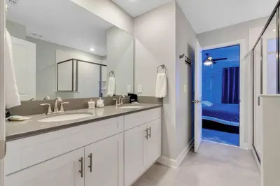 a bathroom with two sinks and a large mirror at NEW 9Bdrm S. Facing Pool on Preserve near Dis/Univ in Kissimmee