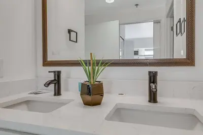 a bathroom sink with a vase with a plant in it at Luxury Private Apt at Disney Area in Orlando