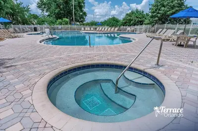 a large swimming pool with chairs and an umbrella at Delightful Studio Condo with Garden View Balcony 7 Mins to Universal in Orlando