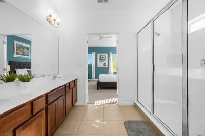 a bathroom with a glass shower and a sink at Upstay - Resort Home w Cinema Pool & Lake View in Kissimmee