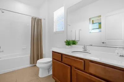 a bathroom with a sink and a toilet and a tub at Upstay - Resort Home w Cinema Pool & Lake View in Kissimmee
