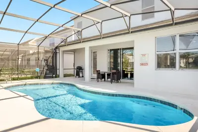 an indoor swimming pool in a house with a glass roof at Upstay - Resort Home w Cinema Pool & Lake View in Kissimmee