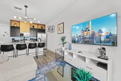 a living room with a large tv on a wall at Modern Townhome 10min to Disney in Kissimmee