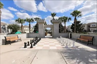 a chess board in the middle of a courtyard with benches at Relaxing vacation resort villa in Orlando