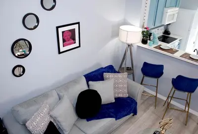 a living room with a gray couch and blue chairs at Level Up Your Vacation Stylish Home Near Disney in Kissimmee