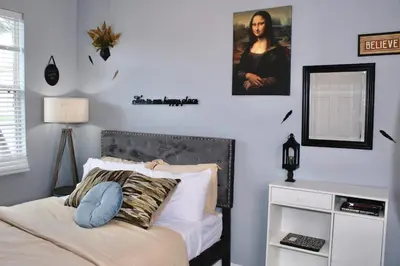 a bedroom with a bed with a mirror on the wall at Level Up Your Vacation Stylish Home Near Disney in Kissimmee
