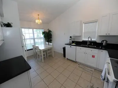 a kitchen with a sink and a table in it at Holiday Hideout by Paradise Resort Vacations in Orlando