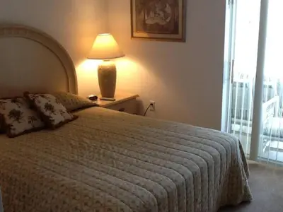 a bedroom with a bed with a lamp and a window at Ruby-Rose Retreat by Paradise Resort Vacations in Kissimmee