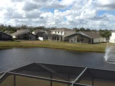 a pond with a fountain in front of houses at Ruby-Rose Retreat by Paradise Resort Vacations in Kissimmee