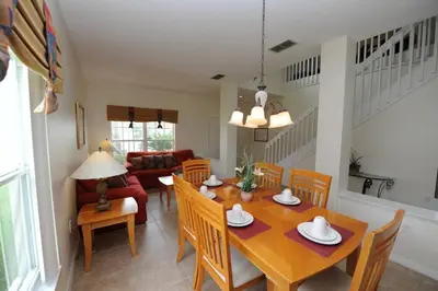 a dining room and living room with a table and chairs at Ruby-Rose Retreat by Paradise Resort Vacations in Kissimmee