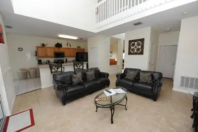 a living room with black leather couches and a table at Ruby-Rose Retreat by Paradise Resort Vacations in Kissimmee