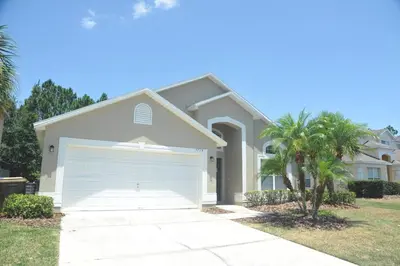 a house with a garage in front of it at Sunshine Serenity by Paradise Resort Vacations in Kissimmee