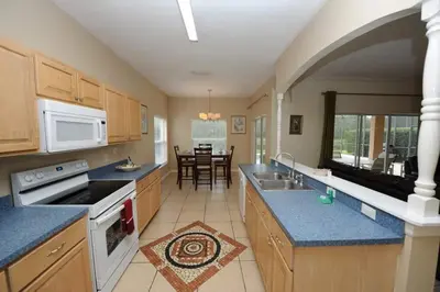 a kitchen with wooden cabinets and blue counter tops at Tranquil Waters Haven by Paradise Resort Vacations in Kissimmee