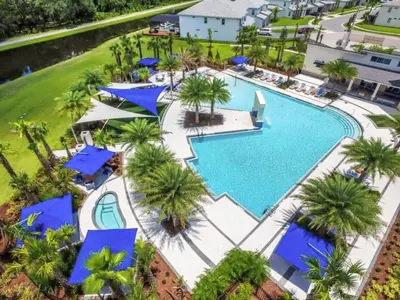 an aerial view of a resort pool with blue umbrellas at UPSTAY- 10BR Mansion wPrivate Pool and Games Room in Kissimmee
