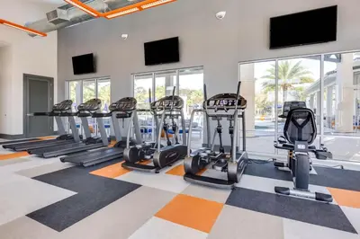 a gym with treadmills and elliptical machines at UPSTAY- 10BR Mansion wPrivate Pool and Games Room in Kissimmee