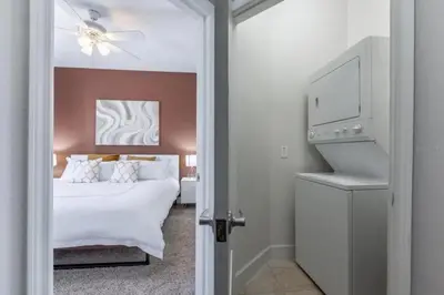 a bedroom with a bed and a washer and dryer at 4 Bedrooms 3 Bathrooms Lucaya Village 2-101 in Kissimmee