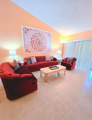 a living room with two red couches and a coffee table at Retro 3 Bedroom Economy Family Home with washer and dryer in unit in Kissimmee