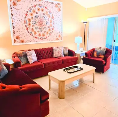 a living room with two red couches and a coffee table at Retro 3 Bedroom Economy Family Home with washer and dryer in unit in Kissimmee