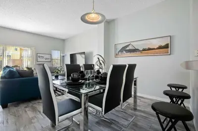 a dining room with a table and chairs and a couch at Casa 3 Quartos no Lake Berkley Resort in Kissimmee