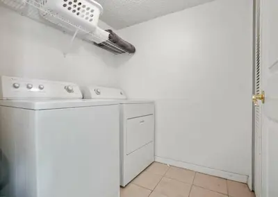 a white laundry room with a washer and dryer at Casa 3 Quartos no Lake Berkley Resort in Kissimmee