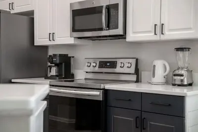 a kitchen with a stove and a microwave at Tiki Palms Play and Pool Near Disney in Kissimmee