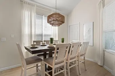 a dining room with a table and chairs and a chandelier at Tiki Palms Play and Pool Near Disney in Kissimmee